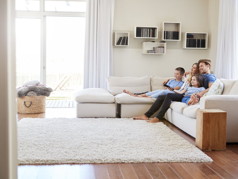 young family sitting together on couch in living room